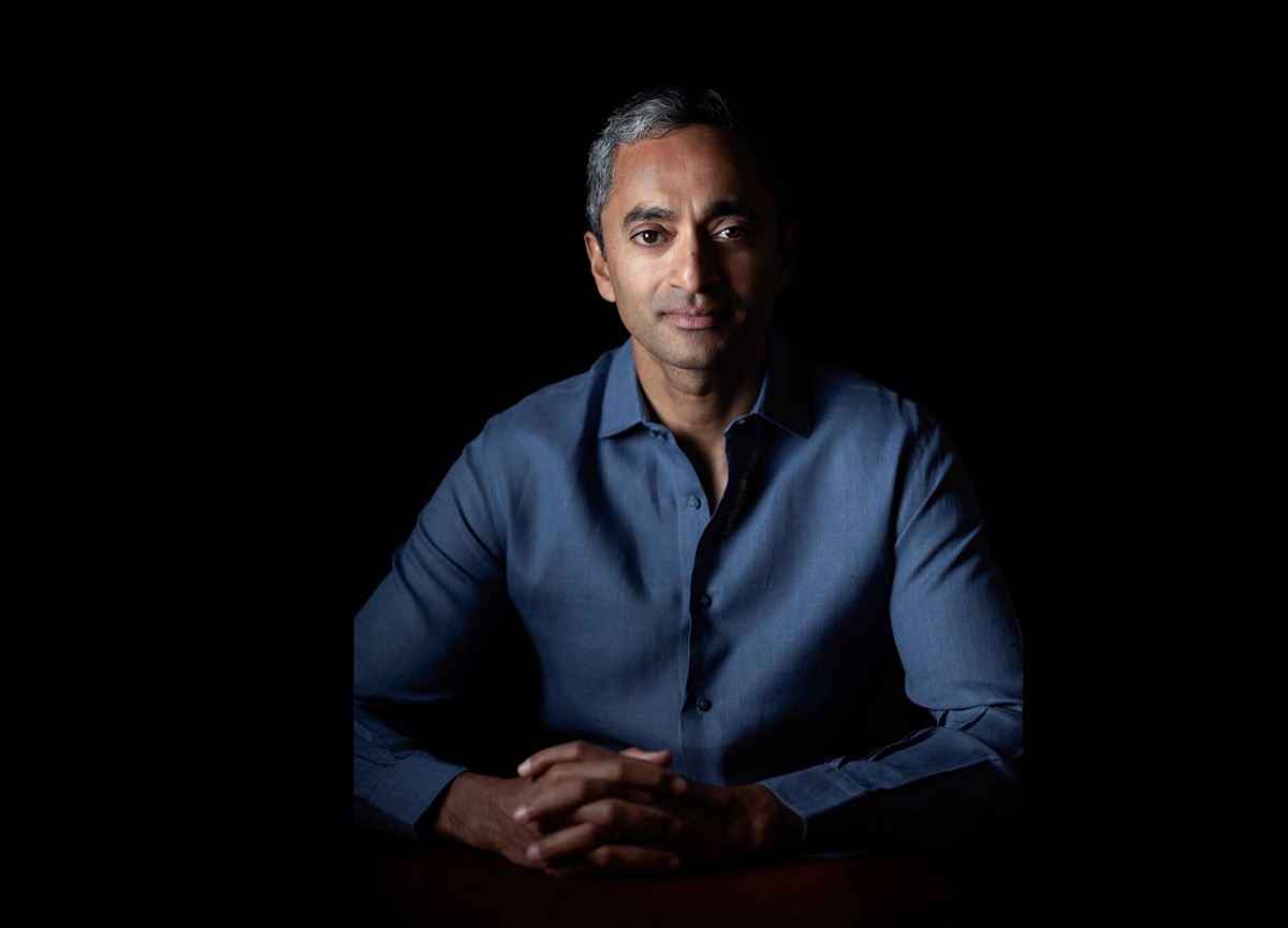 Chamath Palihapitiya dramatic VC portrait · hands clasped · moody lighting