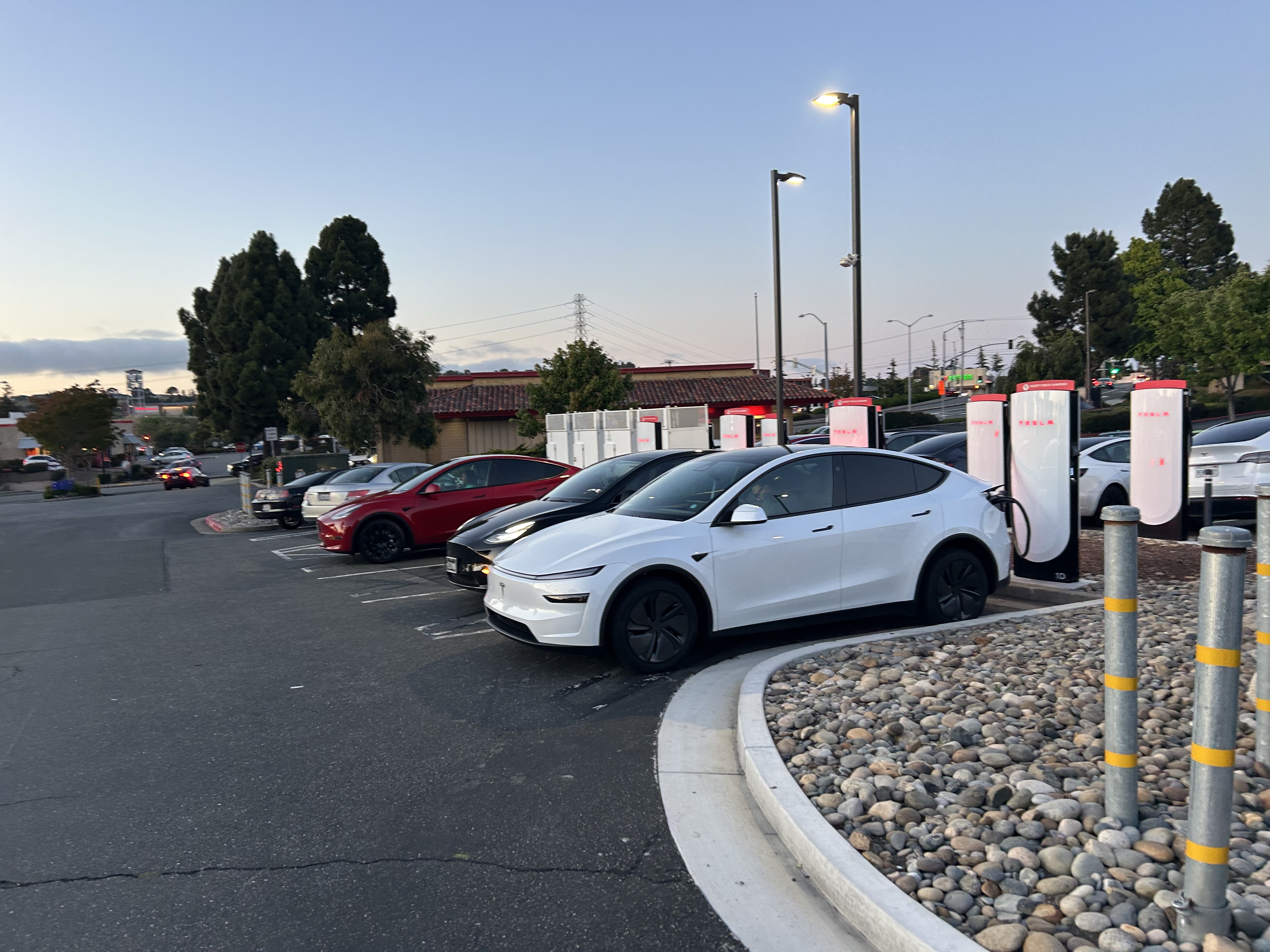 Tesla Supercharger station at dusk — fleet charging, field evidence