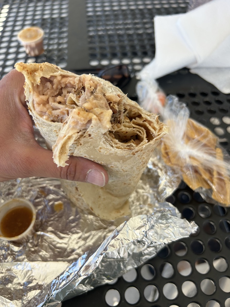 Carnitas burrito cross-section, foil wrap, metal table