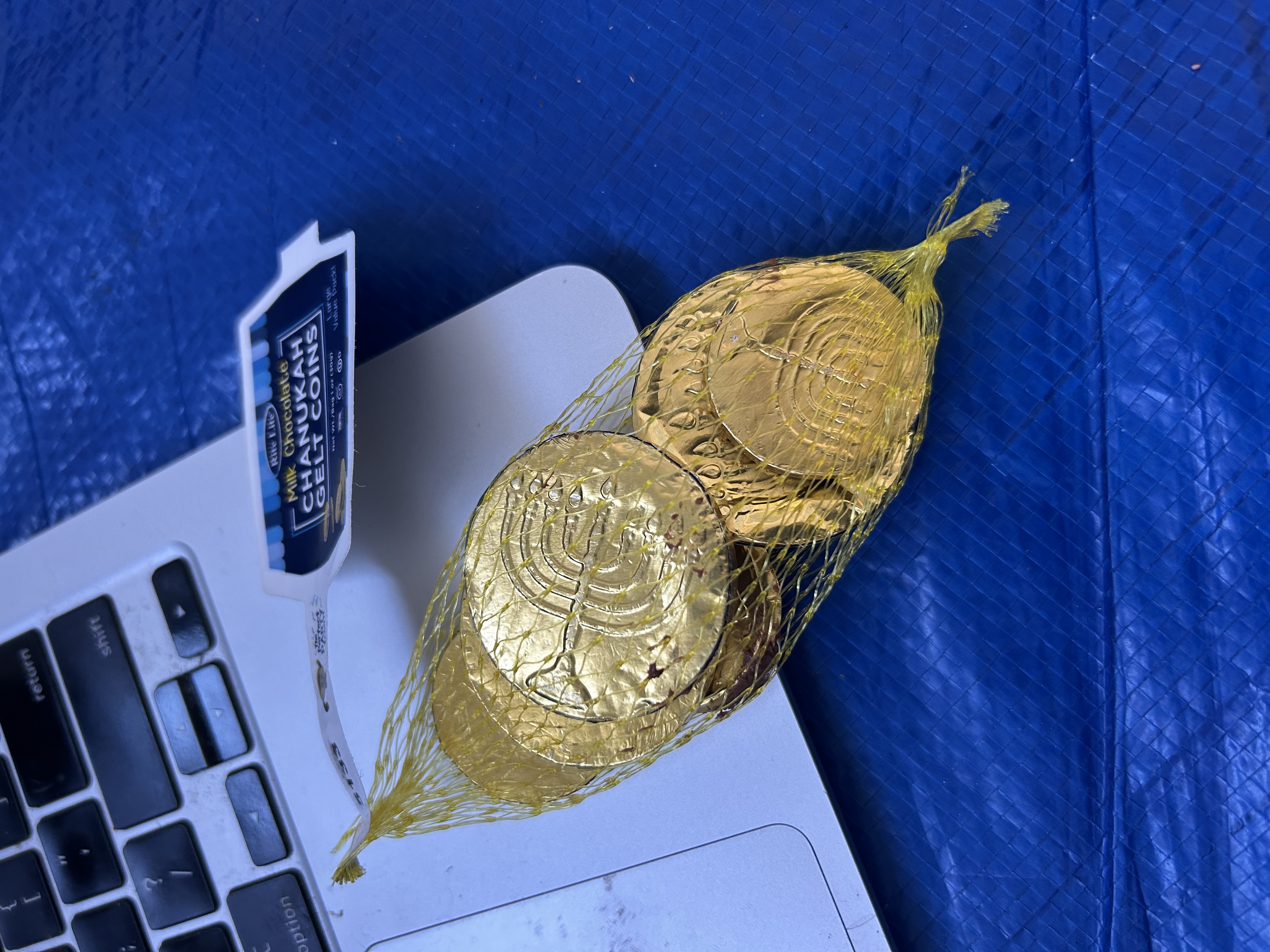 Gold chocolate coin tokens on a MacBook — field token, near to gold, mesh bag, menorah