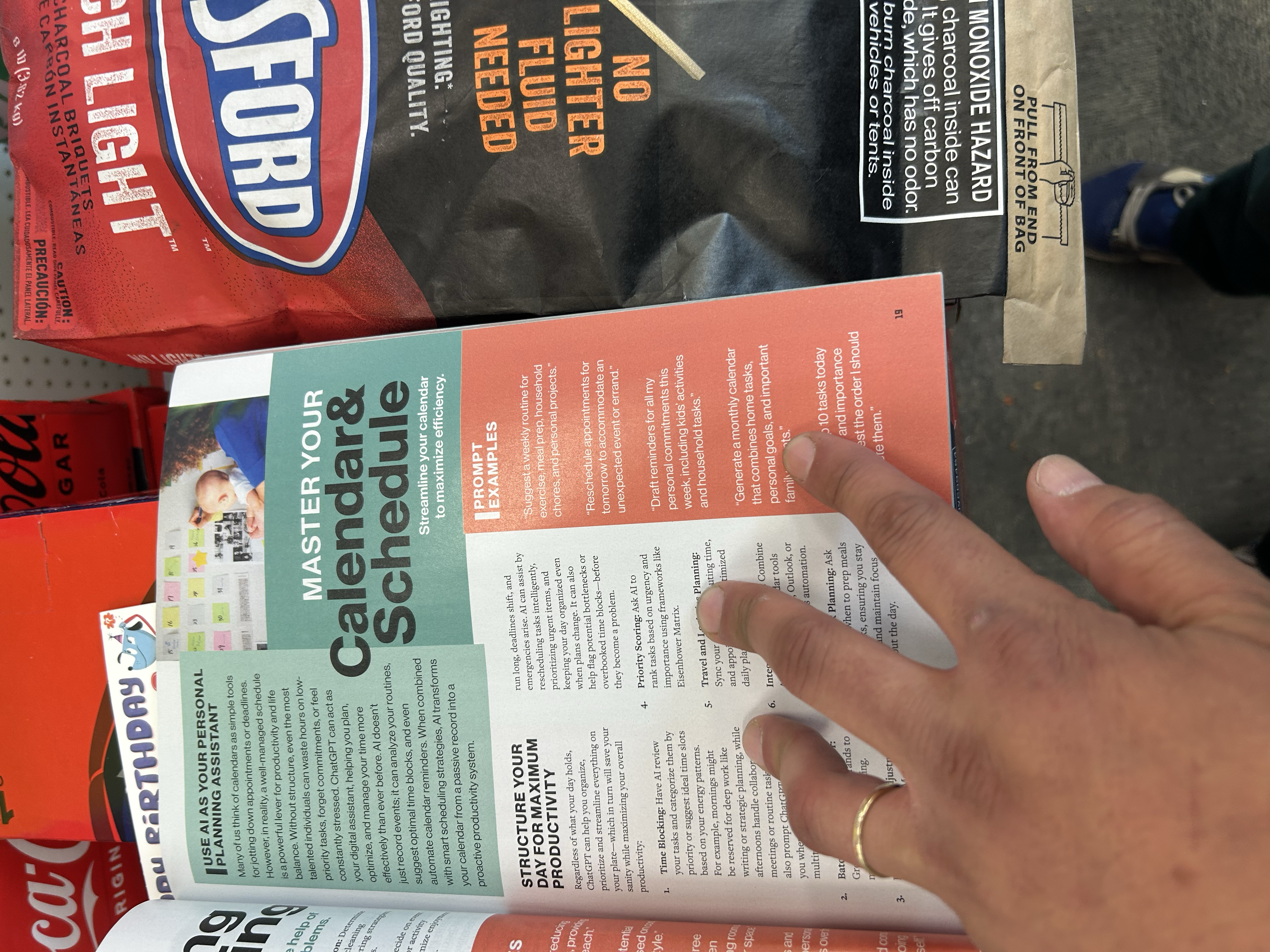 Magazine open to prompt examples page next to Kingsford charcoal bag — actual footage