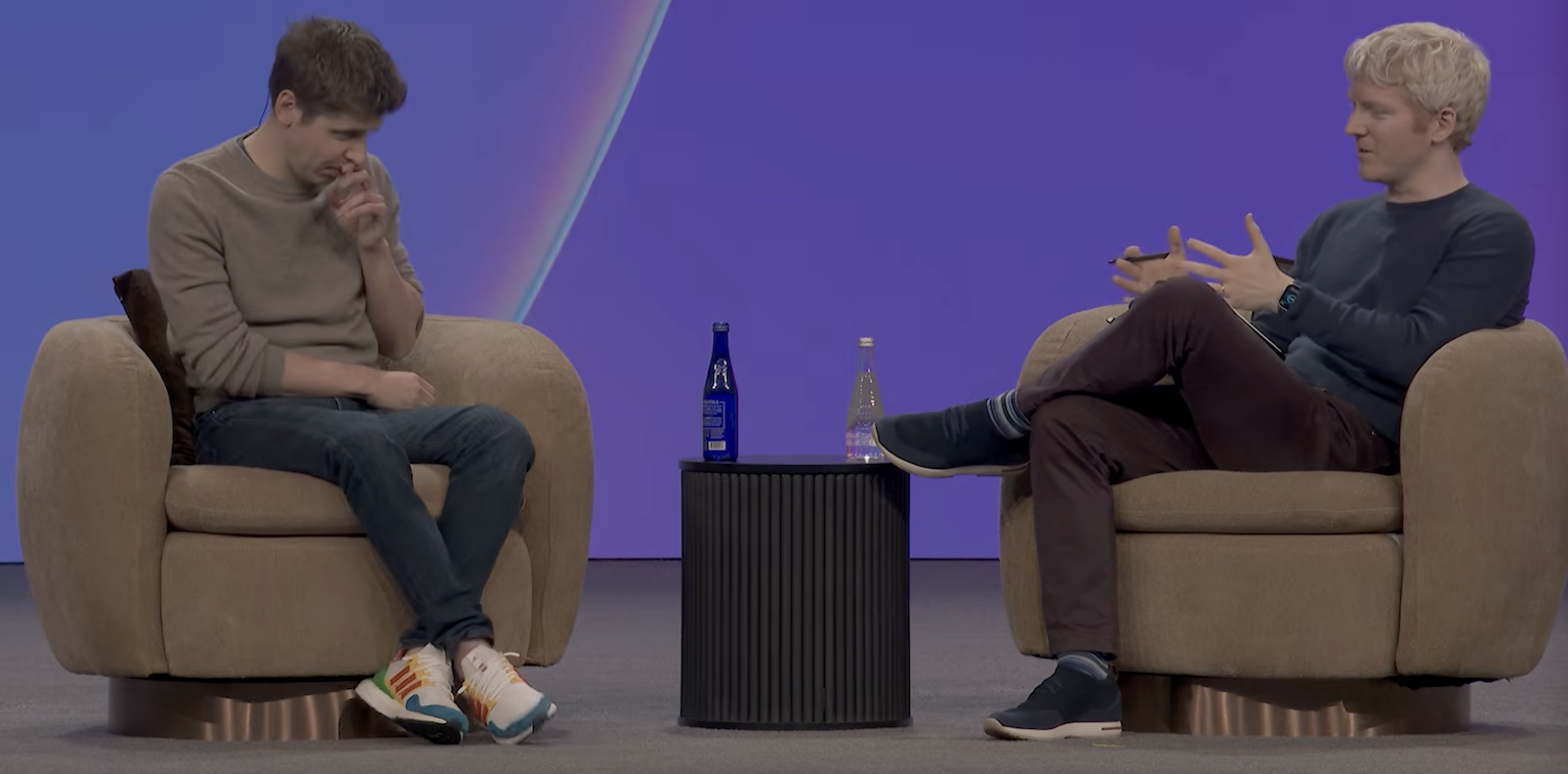 Stripe Sessions — Sam Altman hands at face, hunched, while Patrick Collison gestures openly
